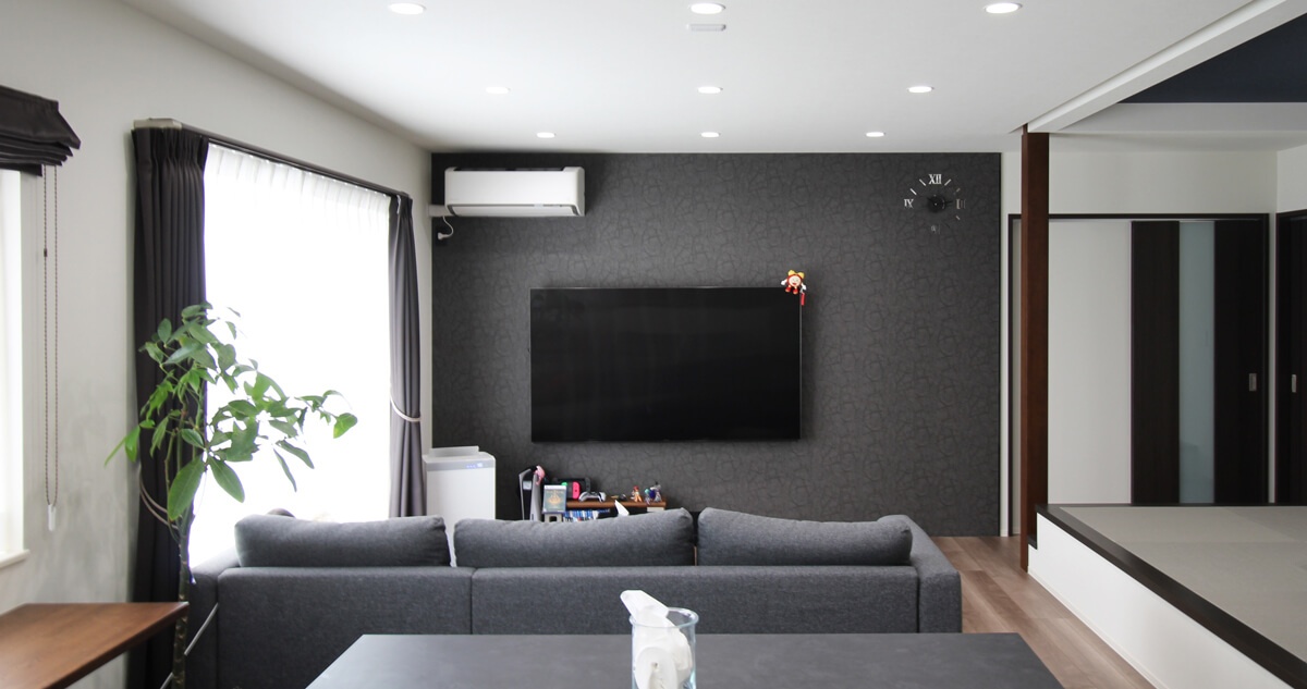 壁掛けテレビとダークトーンのリビング